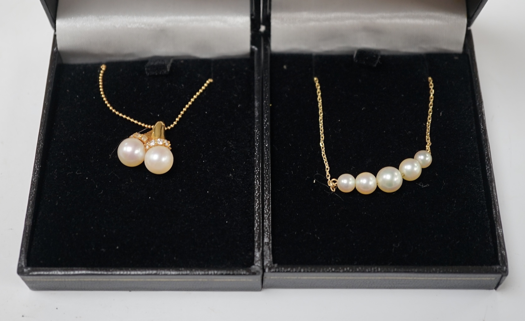 A modern 18k and two stone cultured pearl set pendant necklace, with diamond chip set collars, 42cm, gross weight 5.9 grams, together with a 14l and five stone cultured pearl set necklace, 35cm, gross weight 3 grams. Con